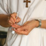 A missionary prepares a vaccination.
