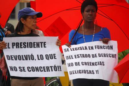 At a December 2014 protest, women hold signs outside Congress in support of legalizing abortion in Santo Domingo, Dominican Republic. © AP PHOTO/EZEQUIEL ABIU LOPEZ