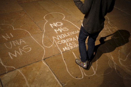 In Malaga, a girl stands over chalk figures of women that are part of a campaign to protest violence against women in Spain. © REUTERS/JON NAZCA